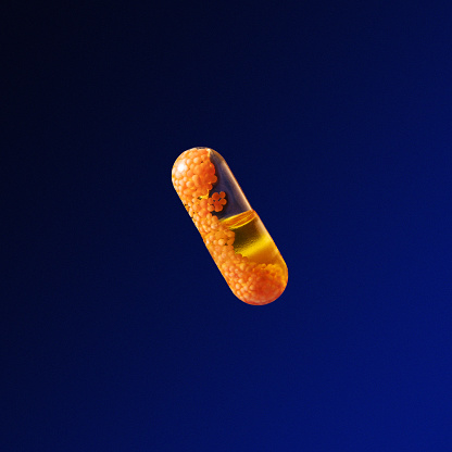 Photo with space for your text. Transparent golden capsule in space, on a blue background.