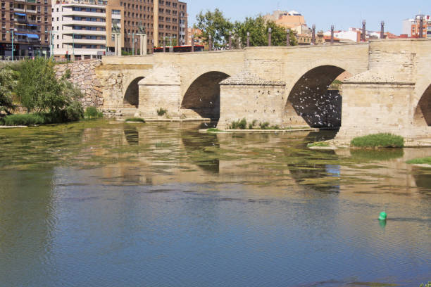 The Stone Bridge and the San Lázaro Parapet are a monumental complex built over the Ebro River in the city of Zaragoza, Spain. Work began on the current bridge in 1401, directed by Gil de Menestral, which was completed forty years later. The parapets date from the 18th century. el puente de piedra y el parapeto de san lázaro son un conjunto monumental construido sobre el río ebro en la ciudad de zaragoza, españa. las obras del actual puente se iniciaron en 1401, dirigidas por gil de menestral, que se terminaron cuarenta años
