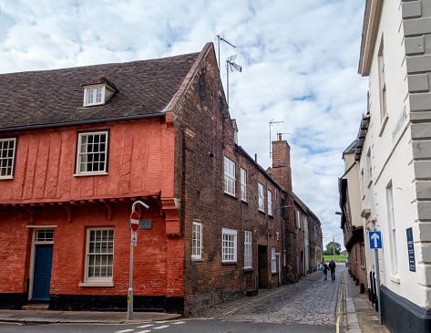 Two people walking down St Margaret’s Lane in King’s Lynn, Norfolk, Eastern England, towards the quay and River Great Ouse. This is one of the oldest parts of this ancient Hanseatic League town.