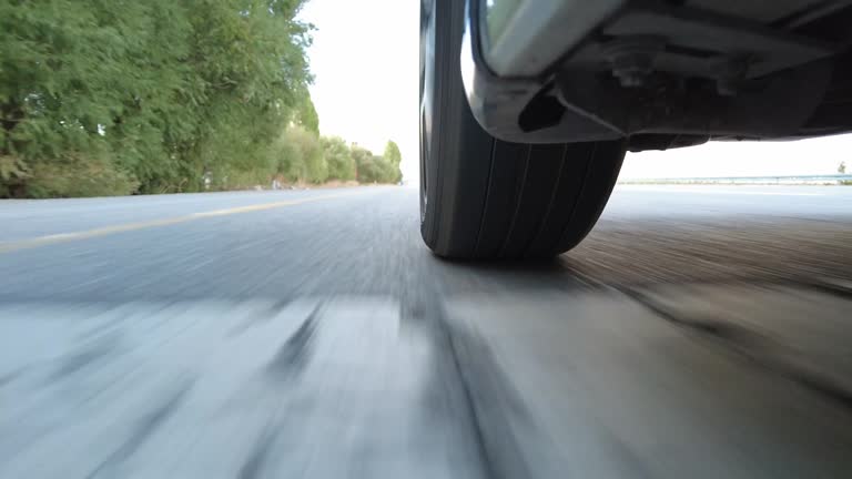 Car wheel spinning on city road POV