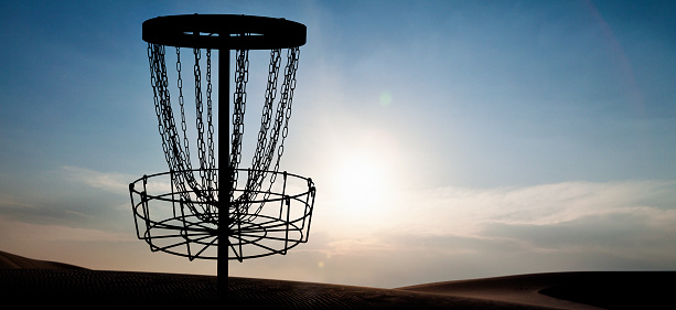 A disc golf basket at sunset in New Mexico, USA.