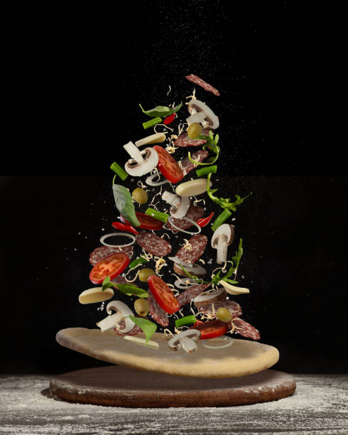 Levitating pizza with different ingredients on a black background. Make your own pizza.