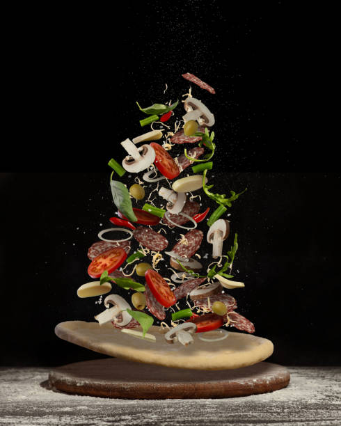 Levitating pizza with different ingredients on a black background. Make your own pizza. Levitating pizza with different ingredients on a black background. Make your own pizza. arugula falling stock pictures, royalty-free photos & images