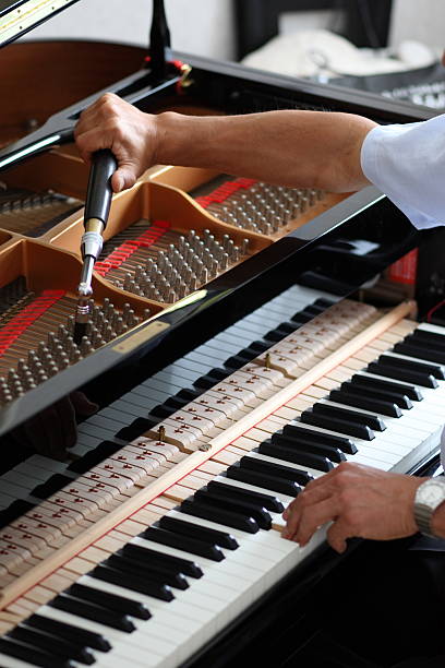 Man working hard to hand tune a piano