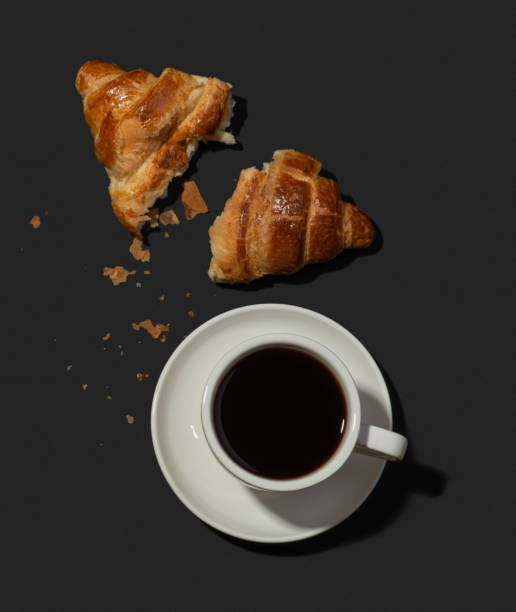 istock Appetizing croissants with coffee on a black background 1442275706