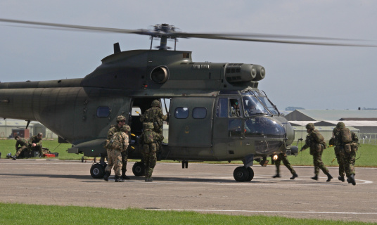 Group of paratroopers jumping from a helicopter.