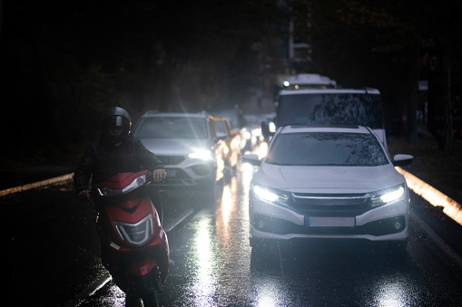 Heavy car traffic on a rainy istanbul evening. In the front is the motorcycle. Taxi, van and cars.