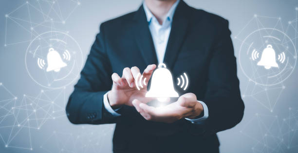 istock Businessman touch finger to press the button. Notification bell button on smartphone app screen close up,App Notification on Smart Phone Screen, Remote online alerts, home security signal. 1442279811