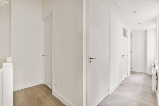 istock a long white hallway with white doors and white walls 1442283377