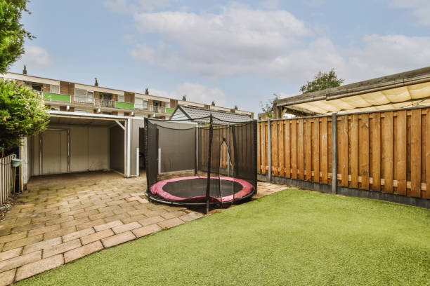 istock a backyard with a trampoline and a fence 1442284793