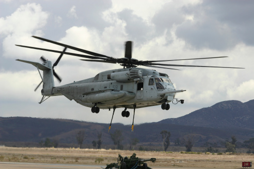 A CH53e Super Stallion delivers a howitzer during a military support demonstration.