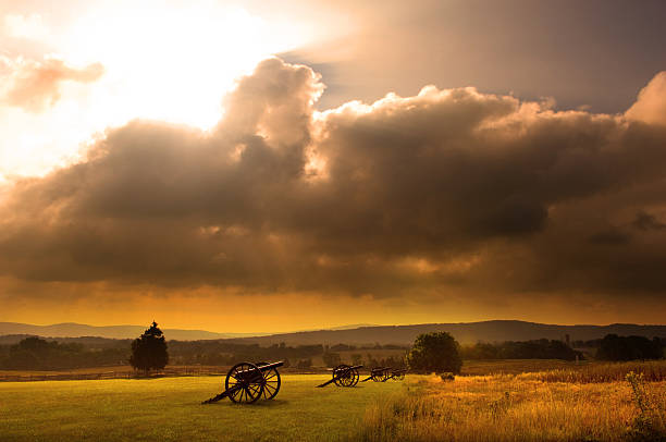 Battlefield Sunrise Sunrise silhouette of monument and cannon at Antietam Battlefield at Sharpsburg, Maryland, USA. civil war stock pictures, royalty-free photos & images