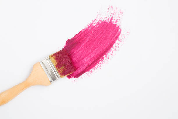 Paintbrush with pink pomade on the white background. Top view. Copy space.