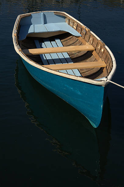 istock Blue dory, dinghy boat on dark water 144229198