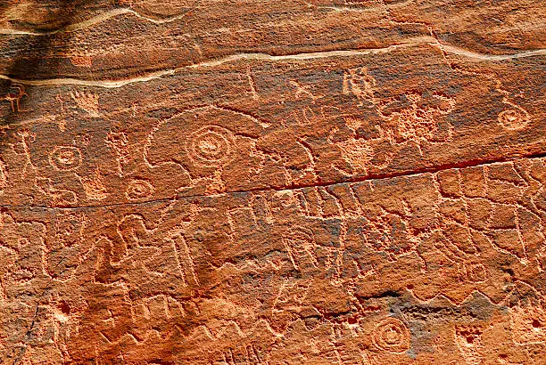 Ancient Indian Petroglyphs carved into red stone at Montezuma Castle National Monument in Arizona