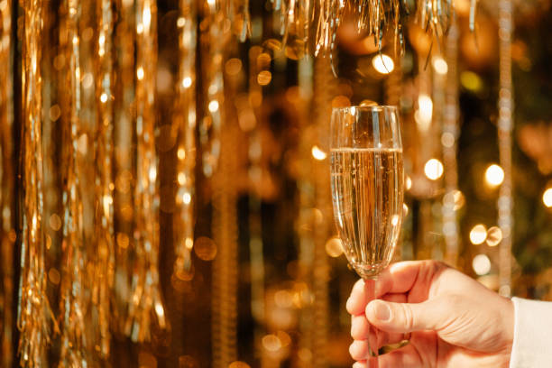 verre de champagne dans la main de l’homme contre luxe lueur dorée décoration pluie chère fête de vacances - polish bread photos et images de collection