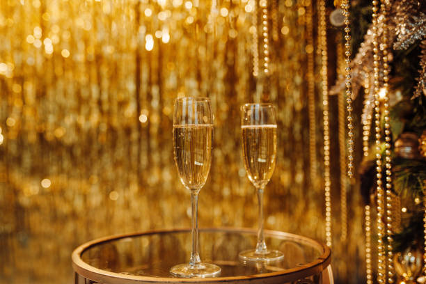 coupes de champagne contre luxe lueur dorée décoration pluie chère fête de vacances - polish bread photos et images de collection