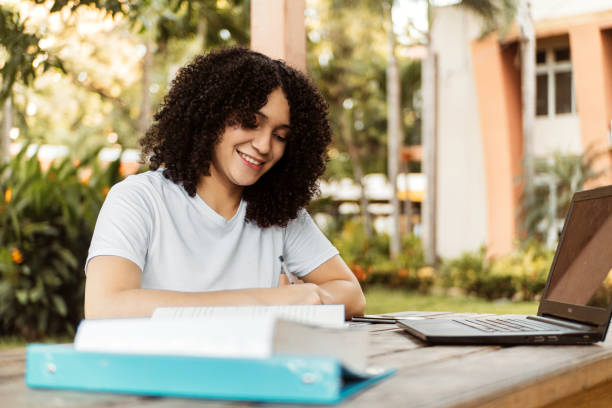 istock Beautiful student studying on line and learning writing notes in a desk in a campus. 1442293664