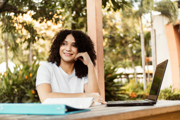 istock Happy student smiling posing sitting on a chair in a desk in a campus. 1442293723