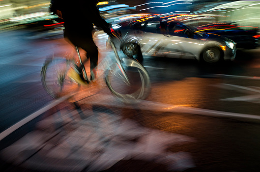 Cyclist riding at night in Toronto ; Vibrant colors