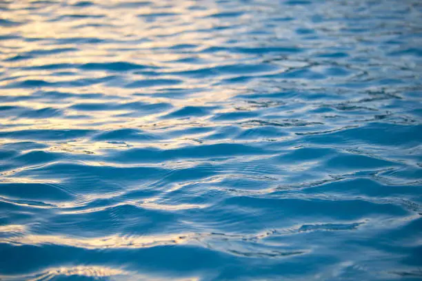 Photo of Closeup seascape surface of blue sea water with small ripple waves.