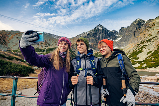 Teenagers are hiking in the Tatras - Slovakia. They are taking photos of beautiful views high in the mountains. 
Lomnický štít visible in the background.
Canon R5