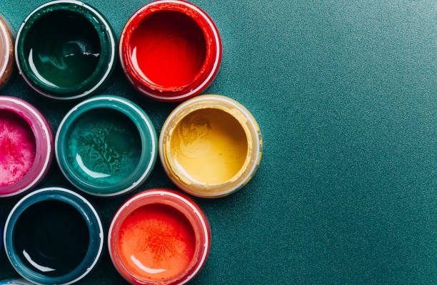 istock Bright, mother-of-pearl, multicolored open cans of paint on a blue background. View from above. 1442296607