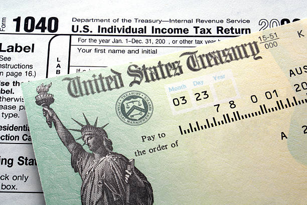Tax return check Tax return check on 1040 form background refund stock pictures, royalty-free photos & images