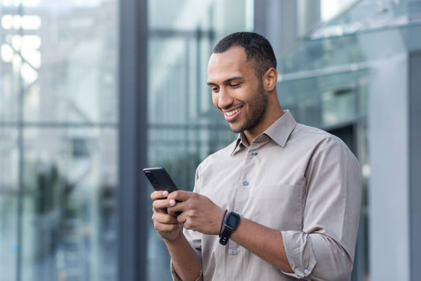 istock hispanic man outside modern office building using smartphone, businessman in shirt typing message and browsing online pages 1442297939