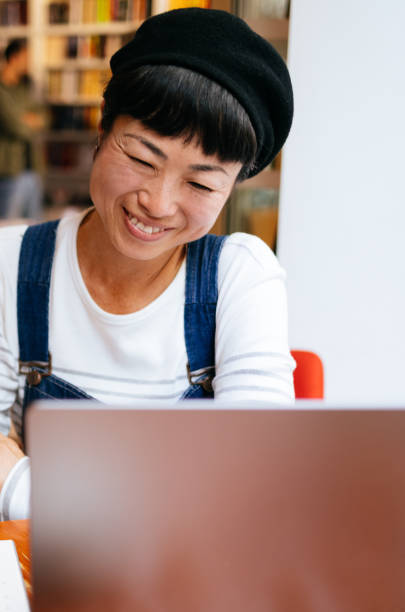 istock Smiling Woman Using A Laptop Computer In The Cafe 1442298491