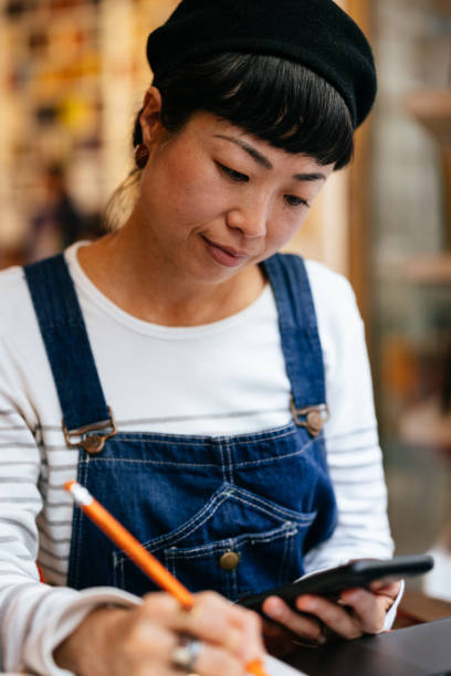 istock Happy Woman Using A Mobile Phone In The Cafe 1442298561