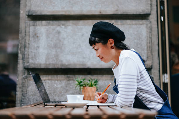 istock Happy Woman Using A Laptop Computer In The Outdoor Cafe 1442299139