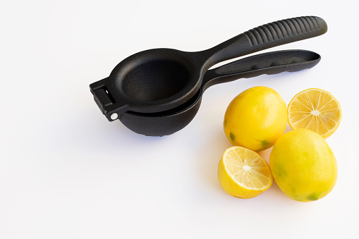 Lemon juicer and lemons on a white background