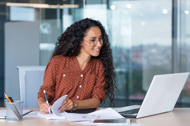 istock Young latin american businesswoman working inside office with documents and laptop, worker paperwork calculates financial indicators smiling and happy with success and results of achievement and work 1442302173