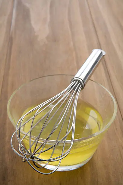 whisking raw egg whites in a glass bowl