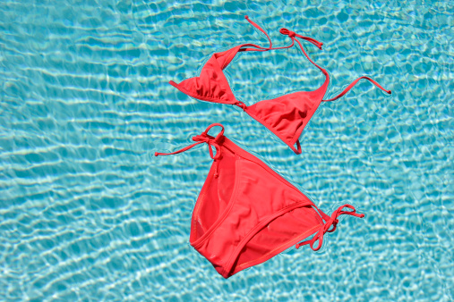 A pink bikini floating in a pool of blue water