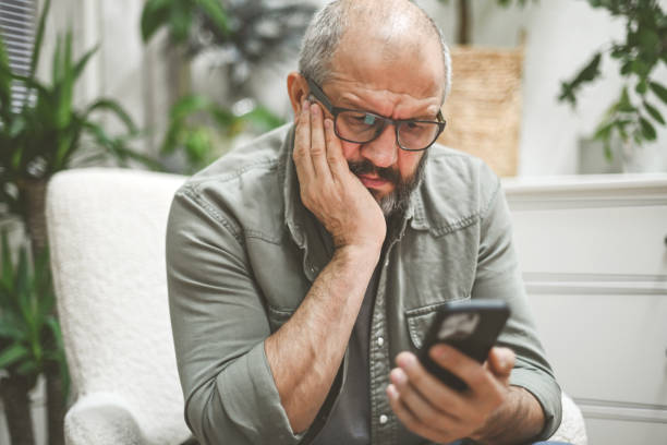 istock mature adult man in home interior ( negative emotion, mobile phone)) 1442305430