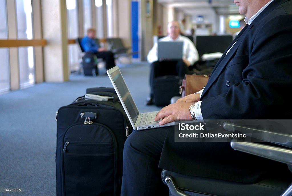 Business man working on lap top at gate in airport Image of a businessman working on a laptop in an airport terminal Adult Stock Photo