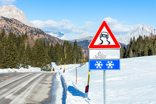 Triangular road sign warning drivers that  the road might be slippery when wet or covered in snow