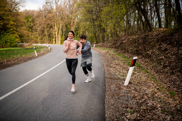 istock Happy athletic couple having fun while running in spring day 1442307993