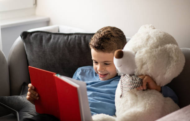 istock Young boy reading a book in his room 1442308012