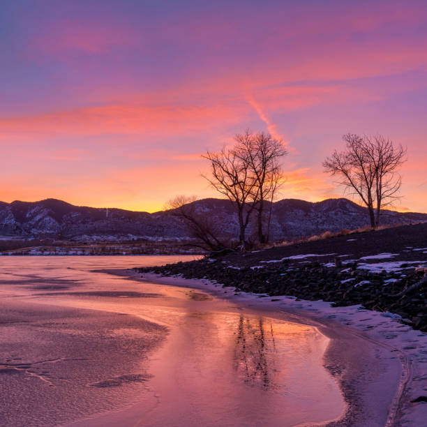 Winter Sunset - Colorful Winter sunset at a frozen mountain lake. Bear Creek Lake, Denver-Lakewood-Morrison, Colorado, USA. stock photo