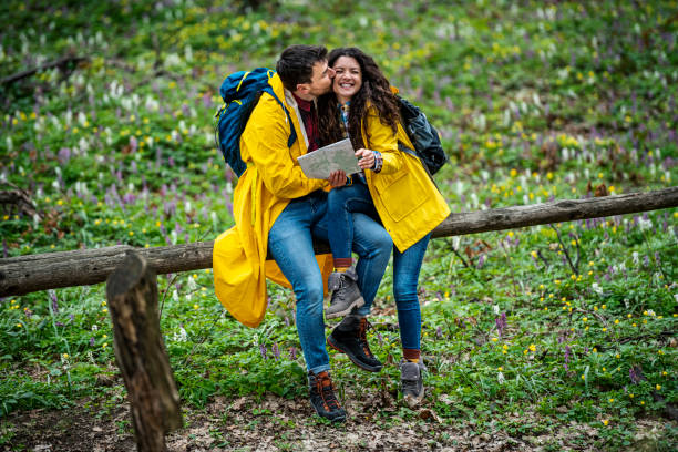 Couple hiking trough forest. Using map to get good direction