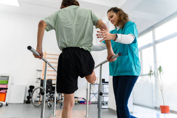 istock Young man uses parallel bars in a rehab center 1442311731