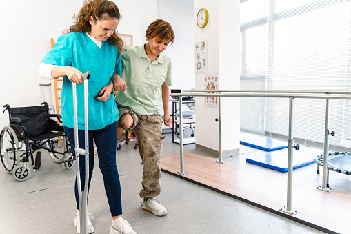 Young military soldier uses crutches in a rehab center