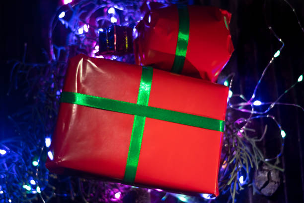 istock christmas and new year background - gift boxes and pine branches on lights background and copy space over dark wall with lights 1442313577