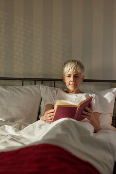 istock Senior woman reading a book in bed. 1442314441