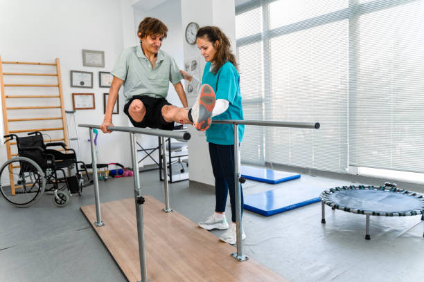 istock Young man uses parallel bars in a rehab center 1442315651