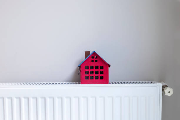 istock House model on closed radiator, space for text. Winter heating efficiency 1442316645