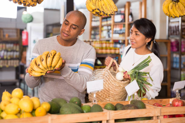 istock Hispanic couple choosing fresh fruit and vegetable in supermarket 1442317878